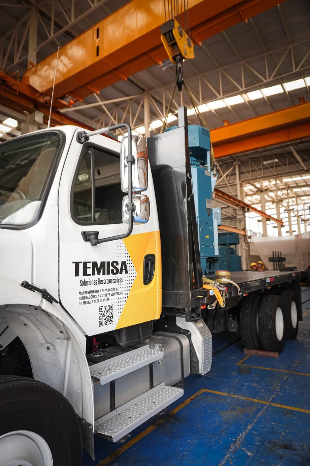 Camión de TEMISA cargando un motor con grúa — logística y proyectos internacionales