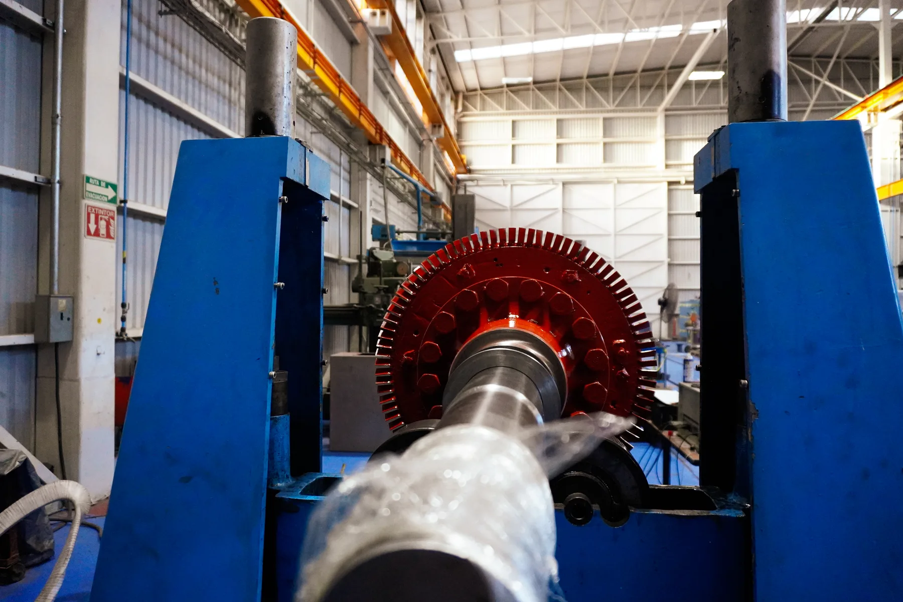 Rotor de núcleo rojo montado entre los bastidores de una máquina de balanceo dinámico, taller de TEMISA