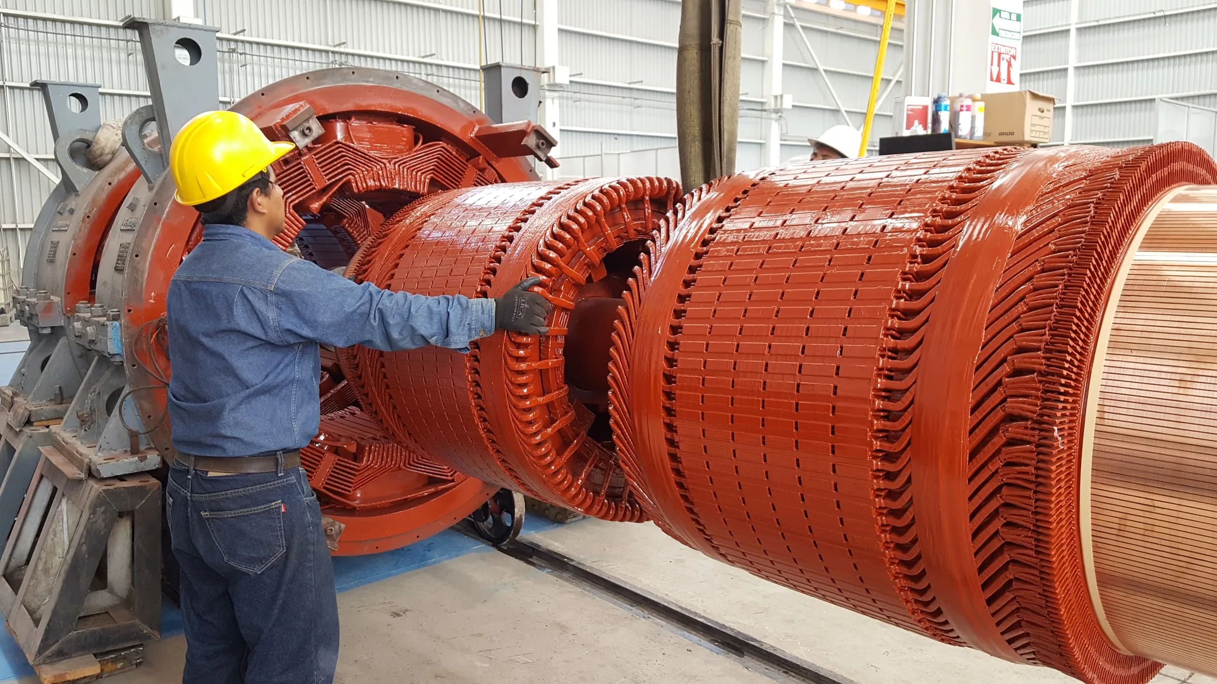 Técnico maniobrando el rotor bobinado de un motor frente al estator abierto durante mantenimiento en TEMISA