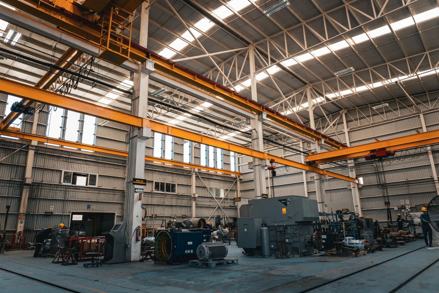 Panorámica interior del taller con grúas, tornos y máquinas herramienta