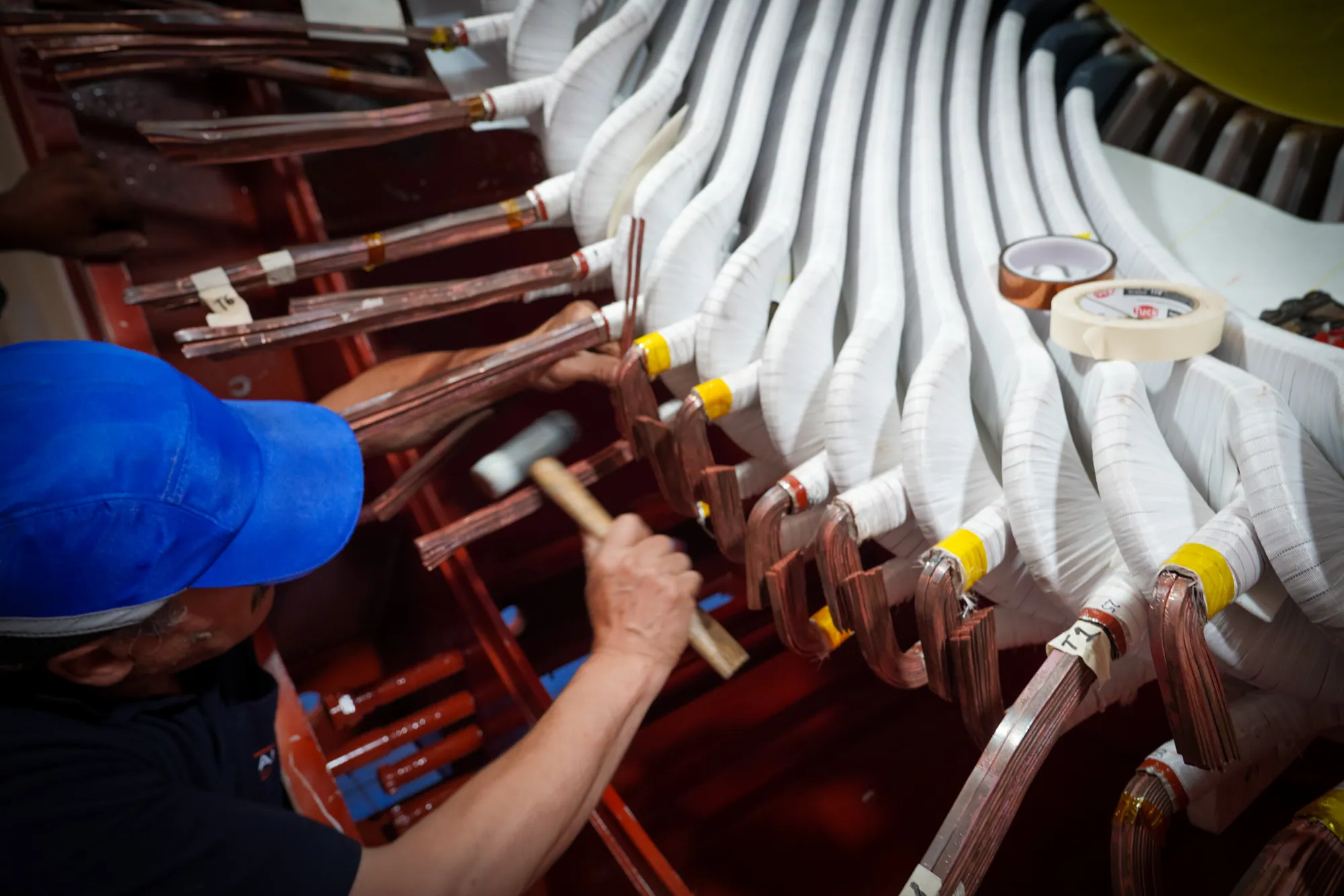 Ajuste de bobinas de cobre durante rebobinado de motor eléctrico en taller TEMISA