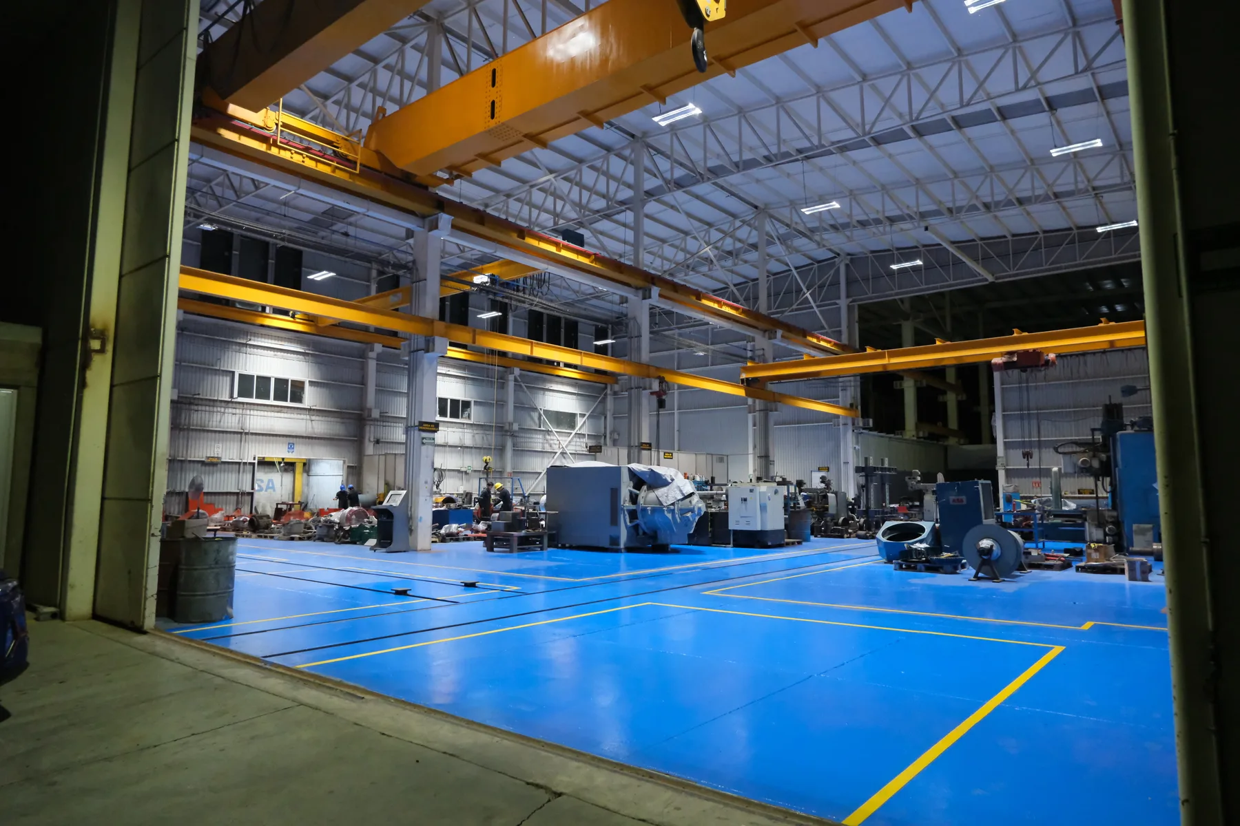 Interior del taller TEMISA con piso epóxico y grúas viajeras, al servicio de la industria de Ciudad de México