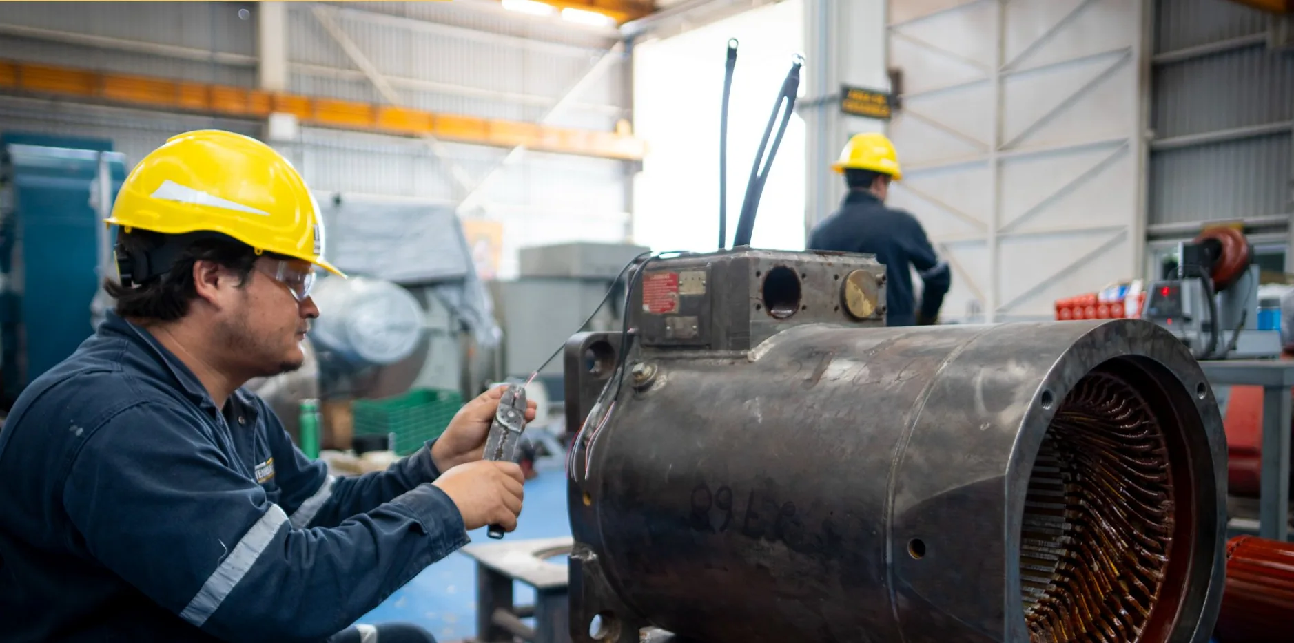 Especialista de TEMISA conectando la punta del equipo de prueba a las salidas del devanado de un motor eléctrico abierto en el taller