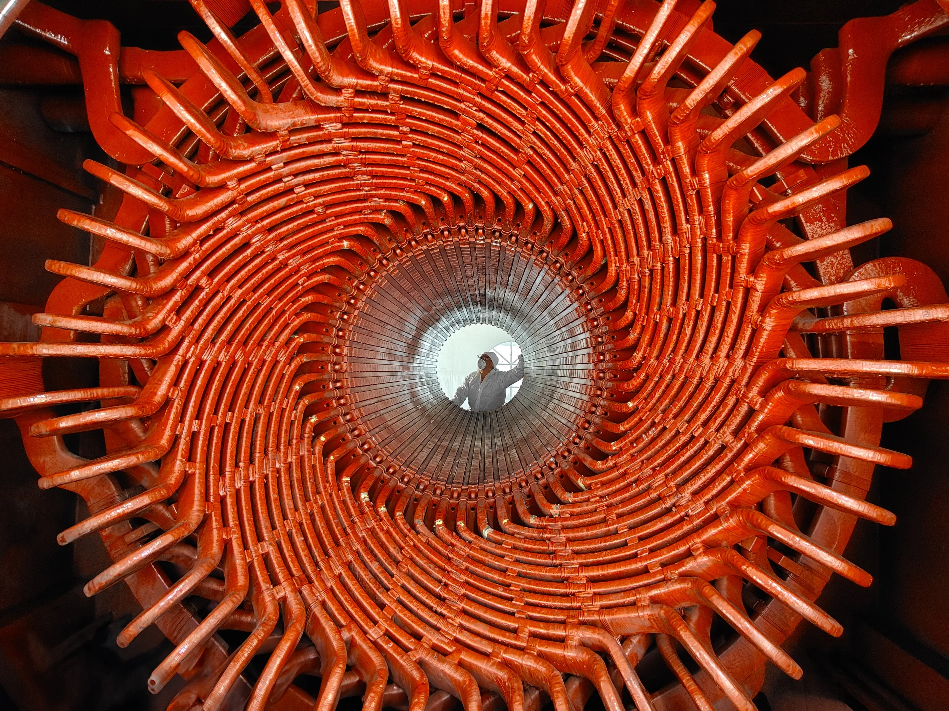 Espiral de cabezales de bobina en un estator, con un técnico al centro del hueco